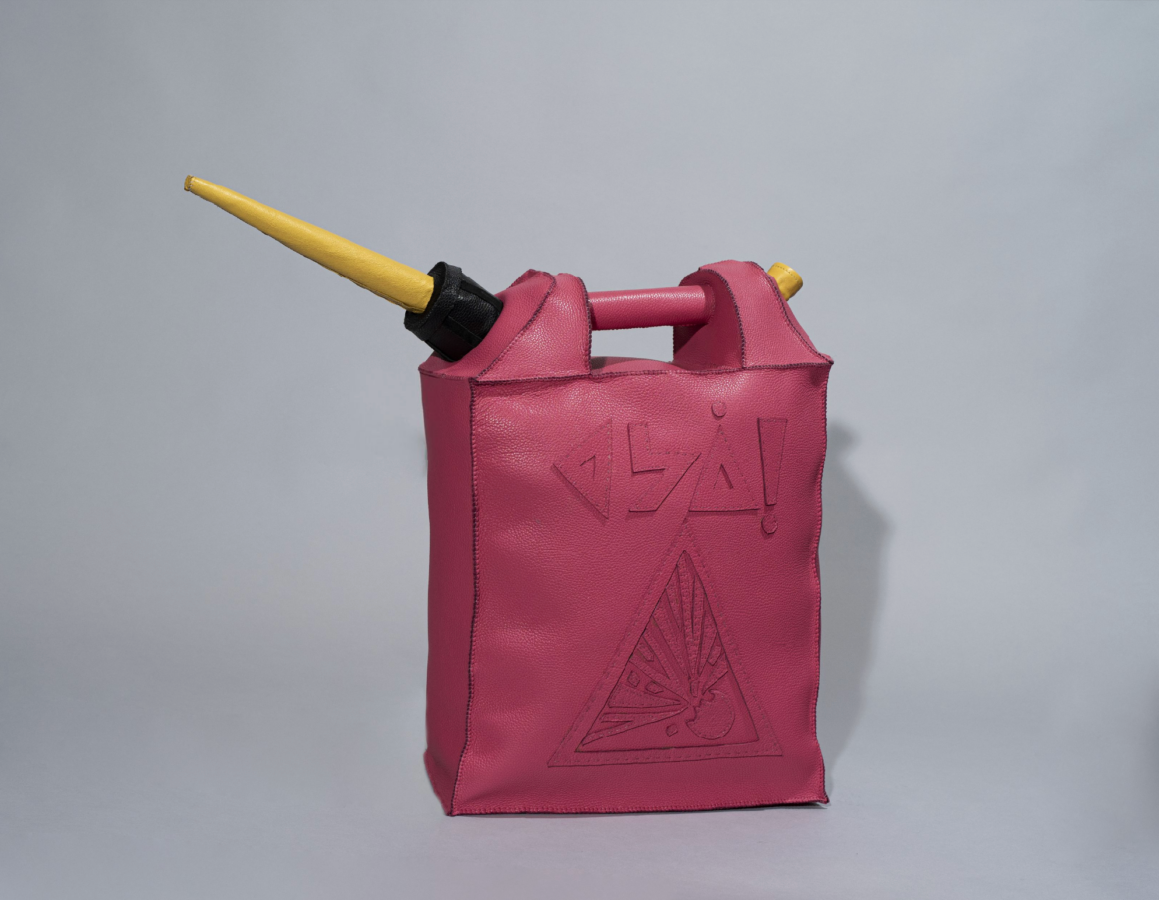 A pink leather bag designed to look like a gas can, featuring a triangular explosion warning symbol and abstract symbols embossed above. It has a black cap and a long yellow spout.